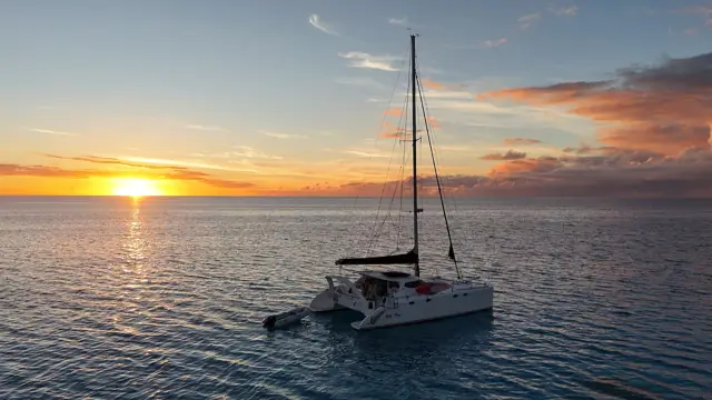 Golden hour drone shot of Mā Tori at anchor as the sun sets