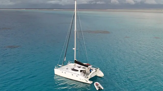 Drone view of Mā Tori and her tender in turquoise lagoon water