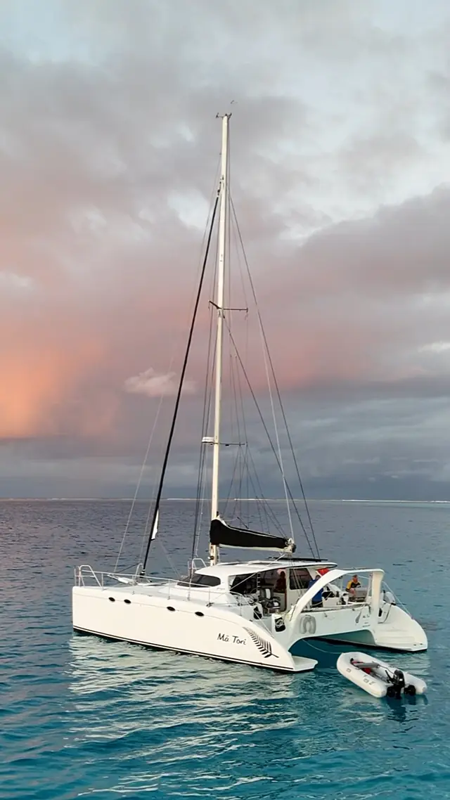 Pastel evening sky and a passing squall behind Mā Tori at anchor