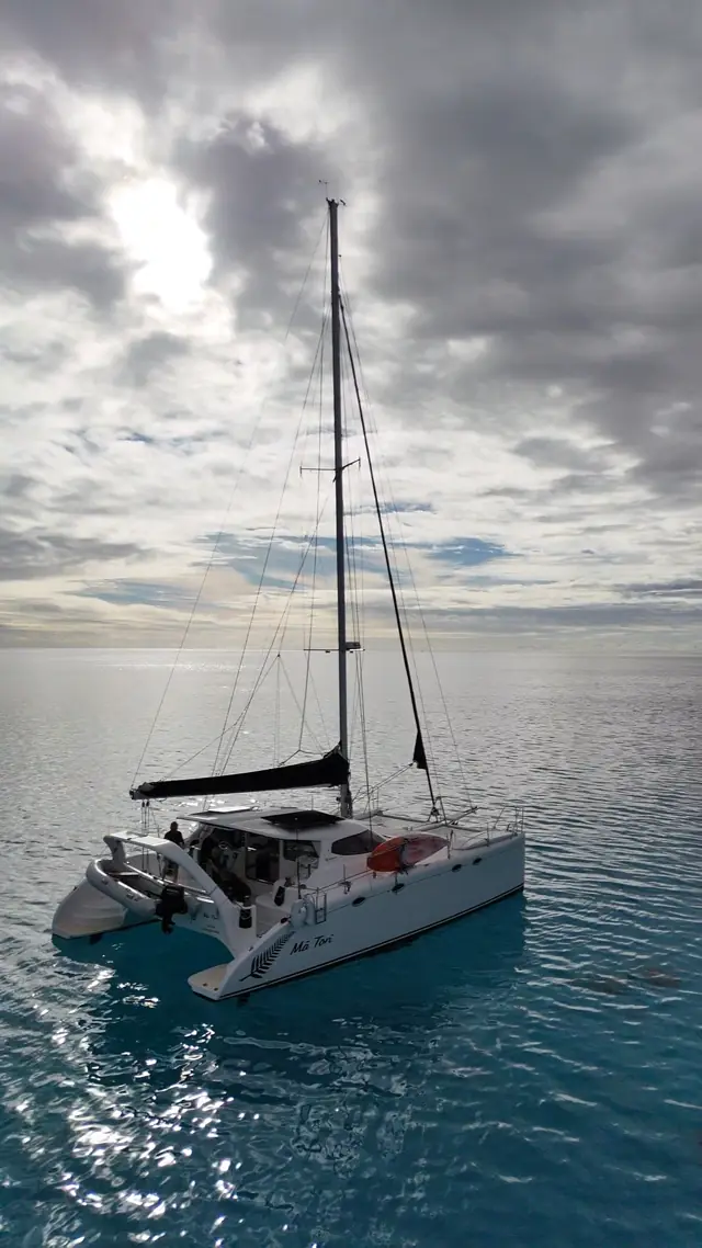 Mā Tori under a silver morning sky on glassy water