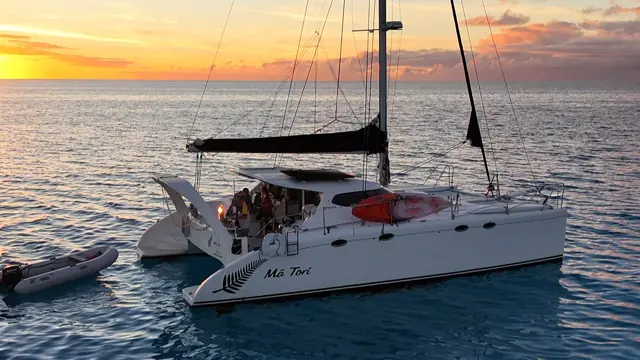 Sunset drone shot of the crew aboard Mā Tori with the tender alongside