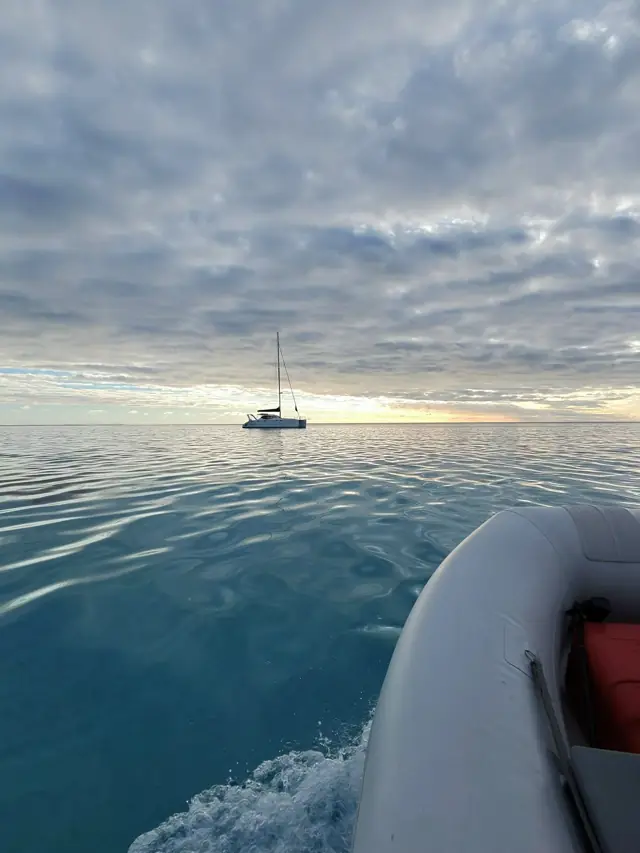 Yacht anchored at dawn on a glassy sea