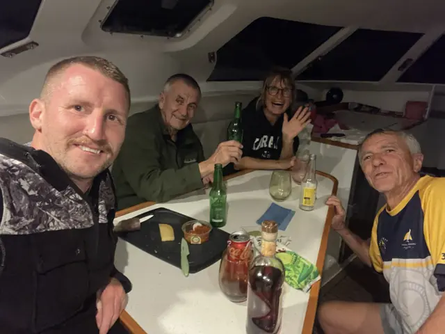 Crew celebrating around the saloon table