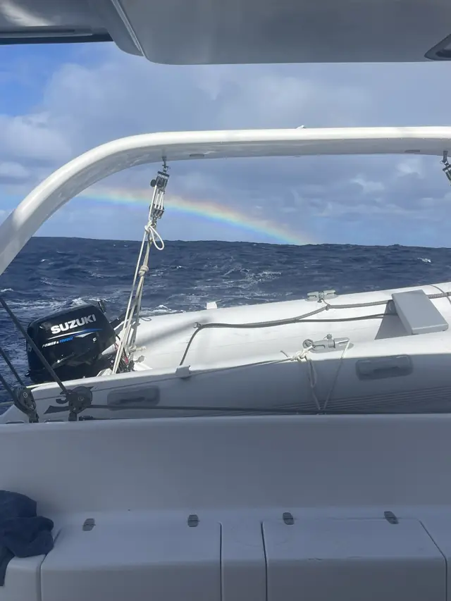 Rainbow arcing over the stern of Mā Tori