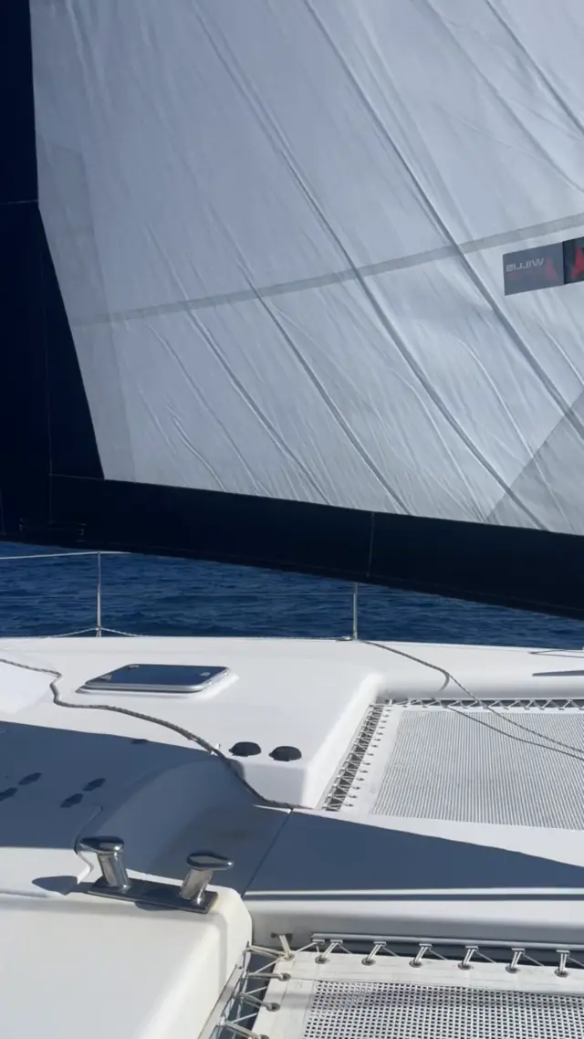Sunlight through the headsail over the foredeck of Mā Tori under way