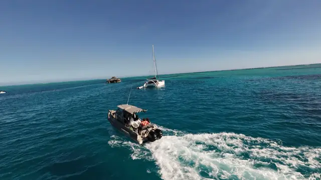 Tender running across turquoise water to the anchorage
