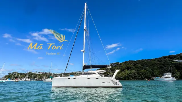Mā Tori Fusion 40 catamaran at anchor, silver fern on her bow